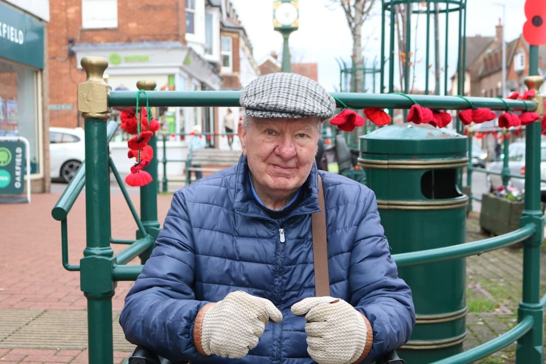service dog retirement — Elderly man wearing a flat cap and puffer jacket.