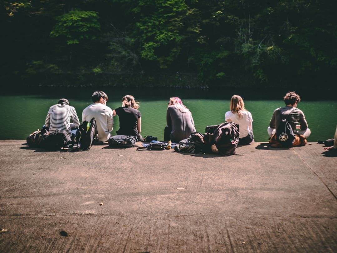 service dog retirement — group of people sitting on gray asphalt road during daytime